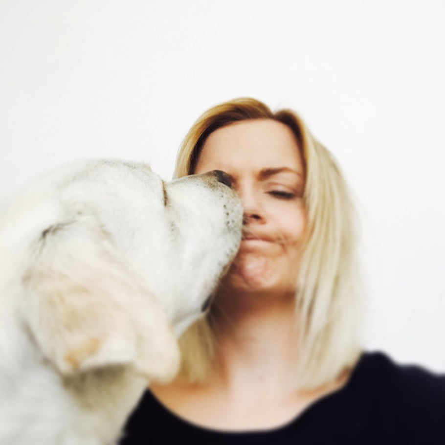 A photograph of heather being kissed by Luna one of her labradors